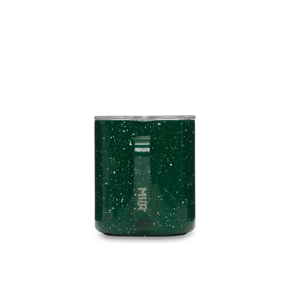 Green tumbler with speckled pattern on a white background